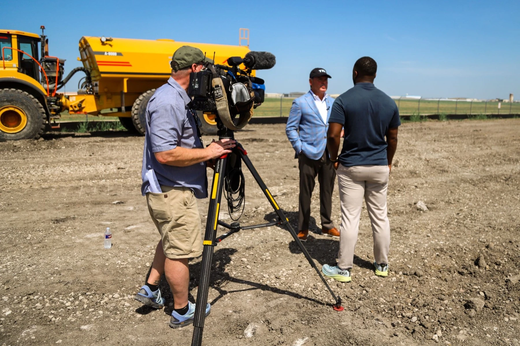 A television crew filming an interview on the construction site of the new McKinney National Airport terminal.