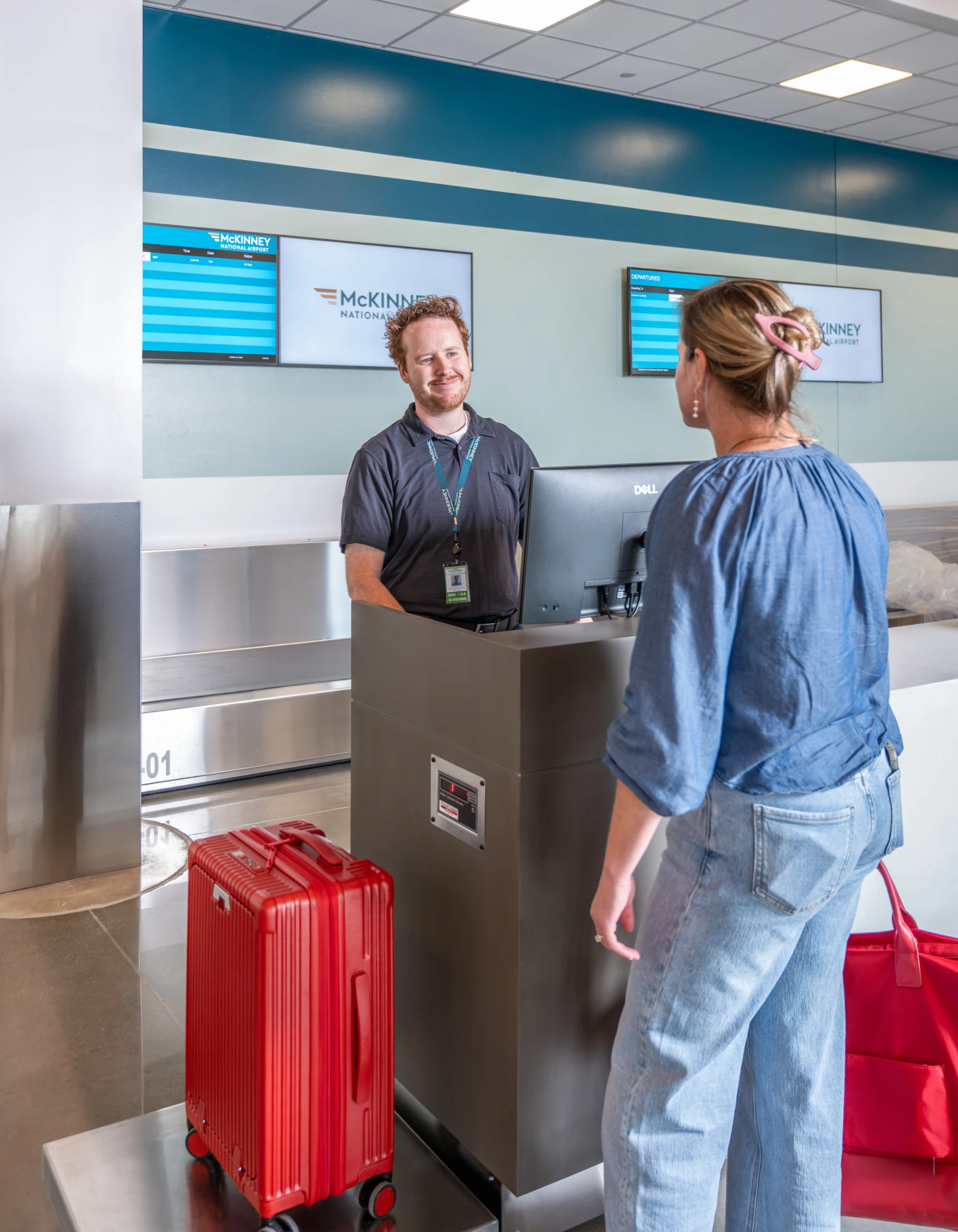 A smiling agent helps a traveler at the McKinney National Airport counter.